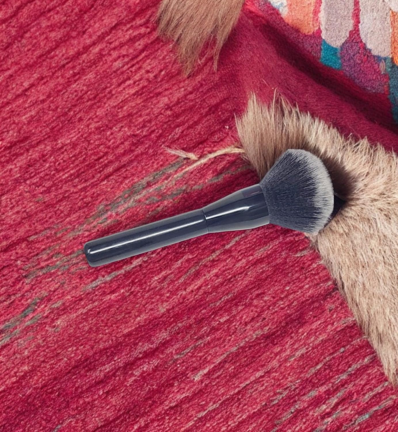 Triangular-shaped kabuki brush with a long, glossy black handle. Featuring fluffy and soft bristles, ideal for applying bronzer, setting powder, and loose powder on both the face and body.